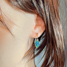 Rose gold opal doublet drop earring worn on the ear, side profile view