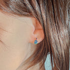 14kt rose gold opal doublet stud earring worn on the ear beneath loose hair