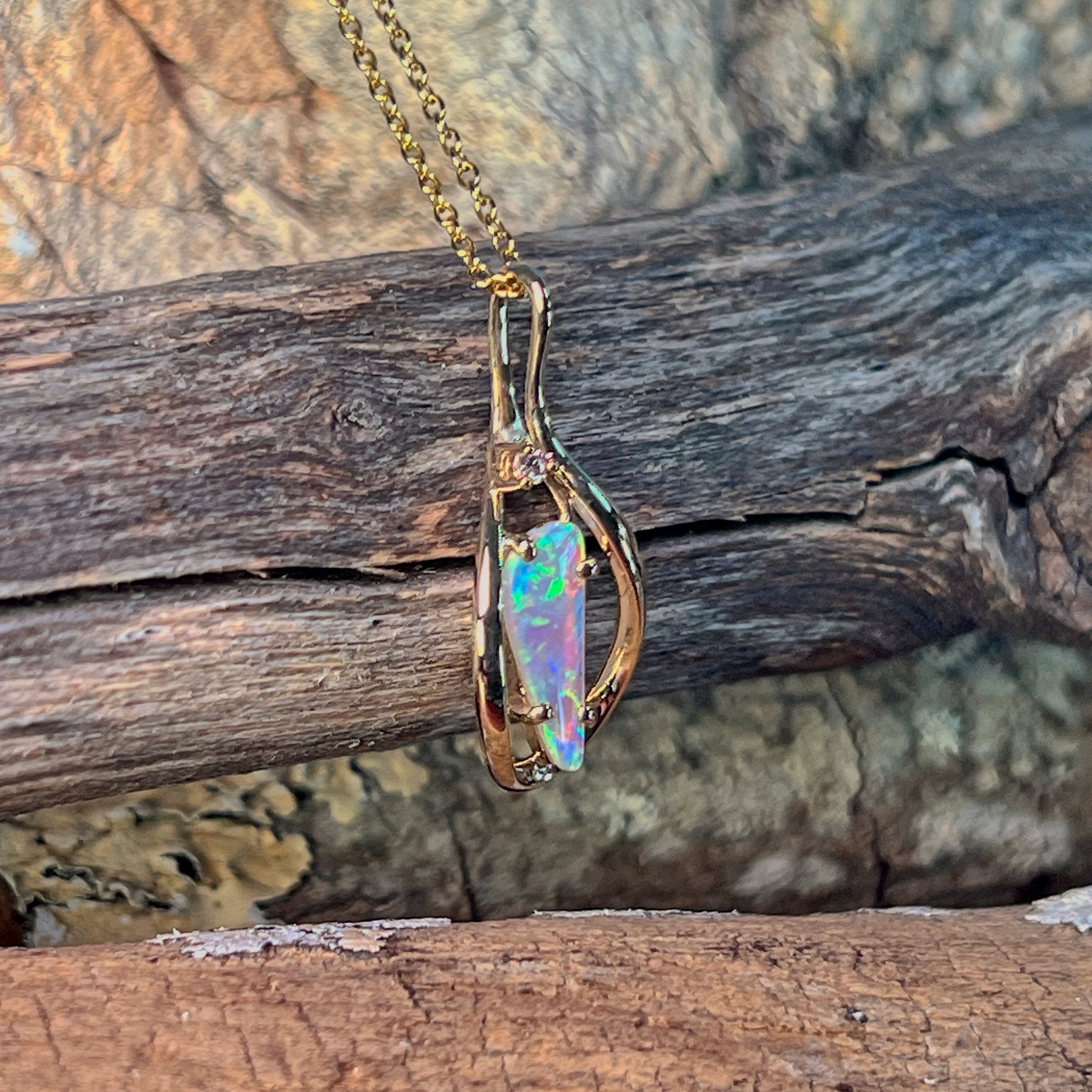 Close view of the triangular crystal opal and the diamond at the pendant bail