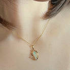 Triangular Australian crystal opal pendant in yellow gold, front view