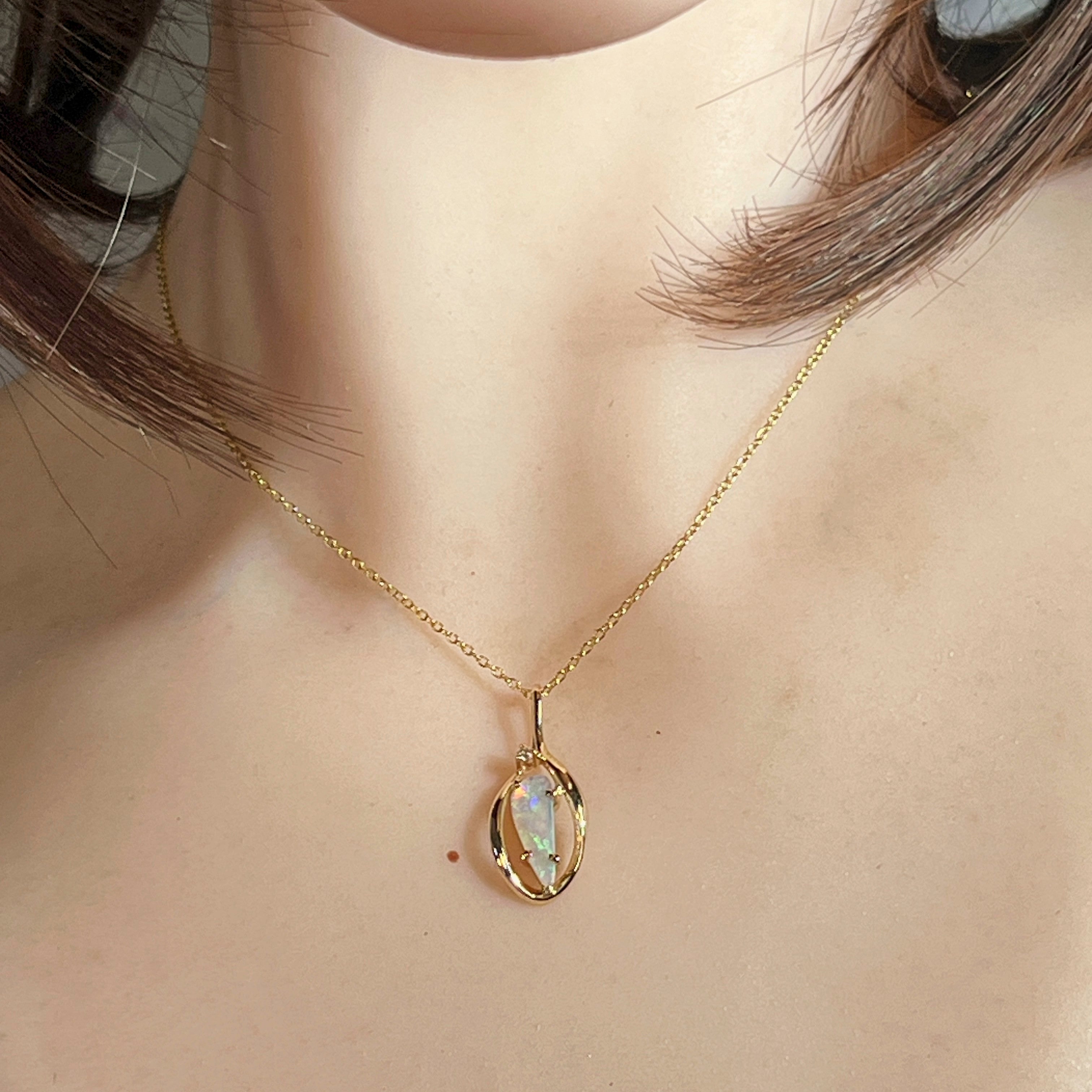 Worn view of the 9kt yellow gold triangular crystal opal pendant