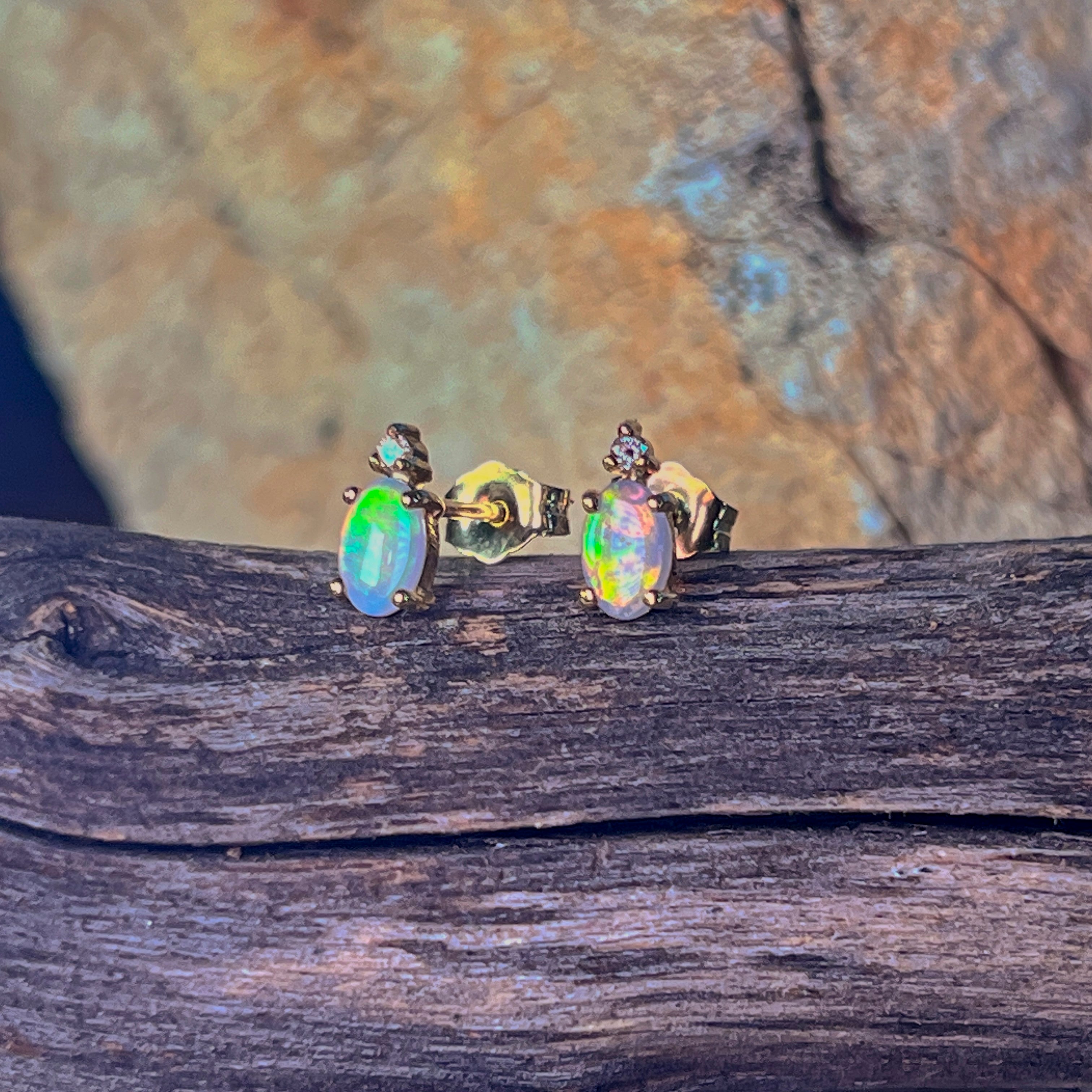 Crystal opal oval studs with diamond accents showing green and orange flash