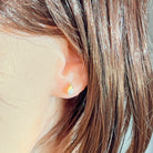 9kt yellow gold oval crystal opal stud with diamond accent shown worn