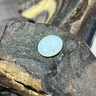 White opal 4.89ct catching bright blue-green pinfire under direct light