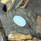 Angled view of the 5.15ct white opal oval, soft pastel shimmer across the face