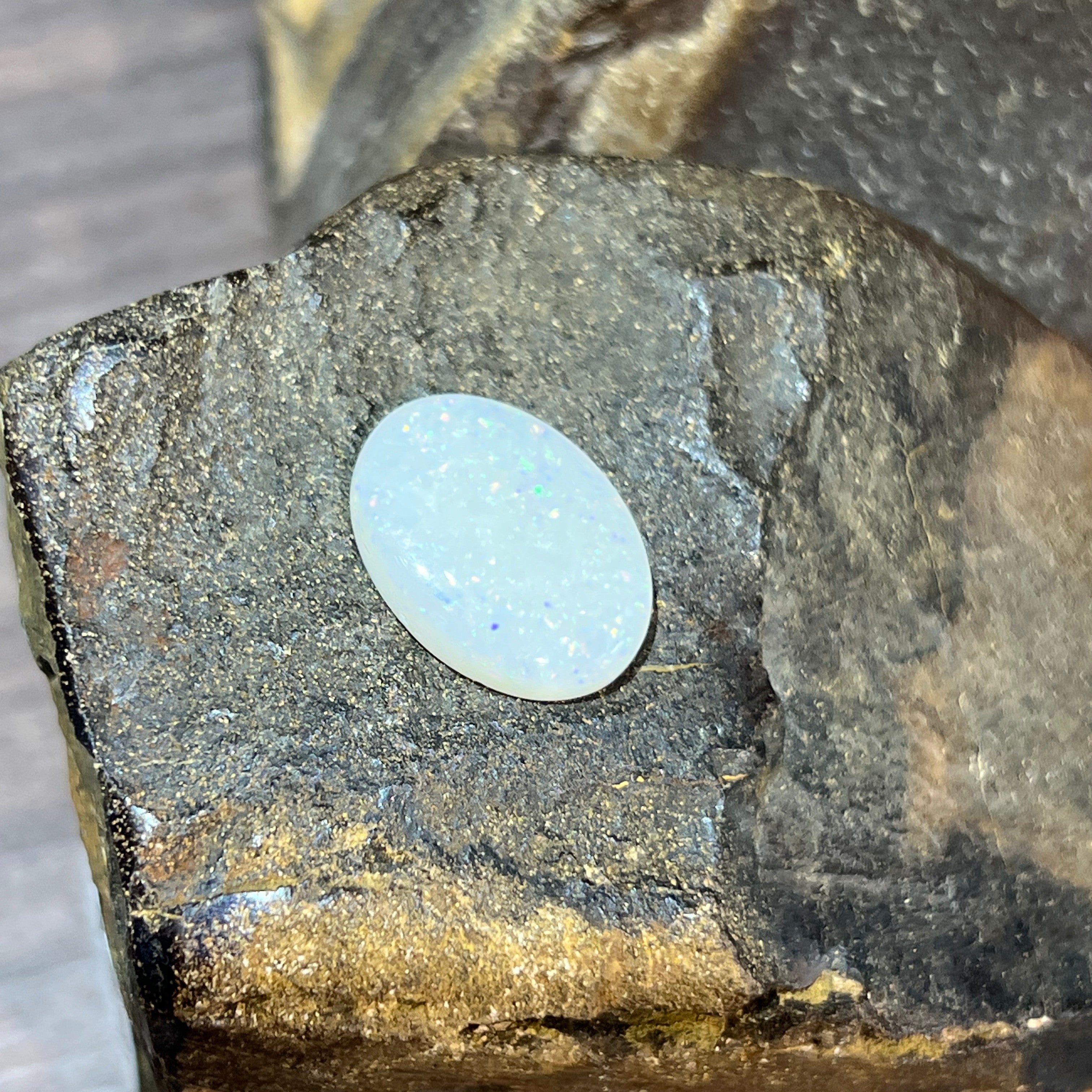 5.15ct white opal cabochon, fine silvery-blue shimmer across a milky white body