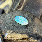 Angled view of the 18x11mm crystal opal, green and yellow flashes across its length