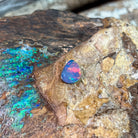 Rolling red fire across a violet-blue 1.47ct Australian opal doublet on weathered rock