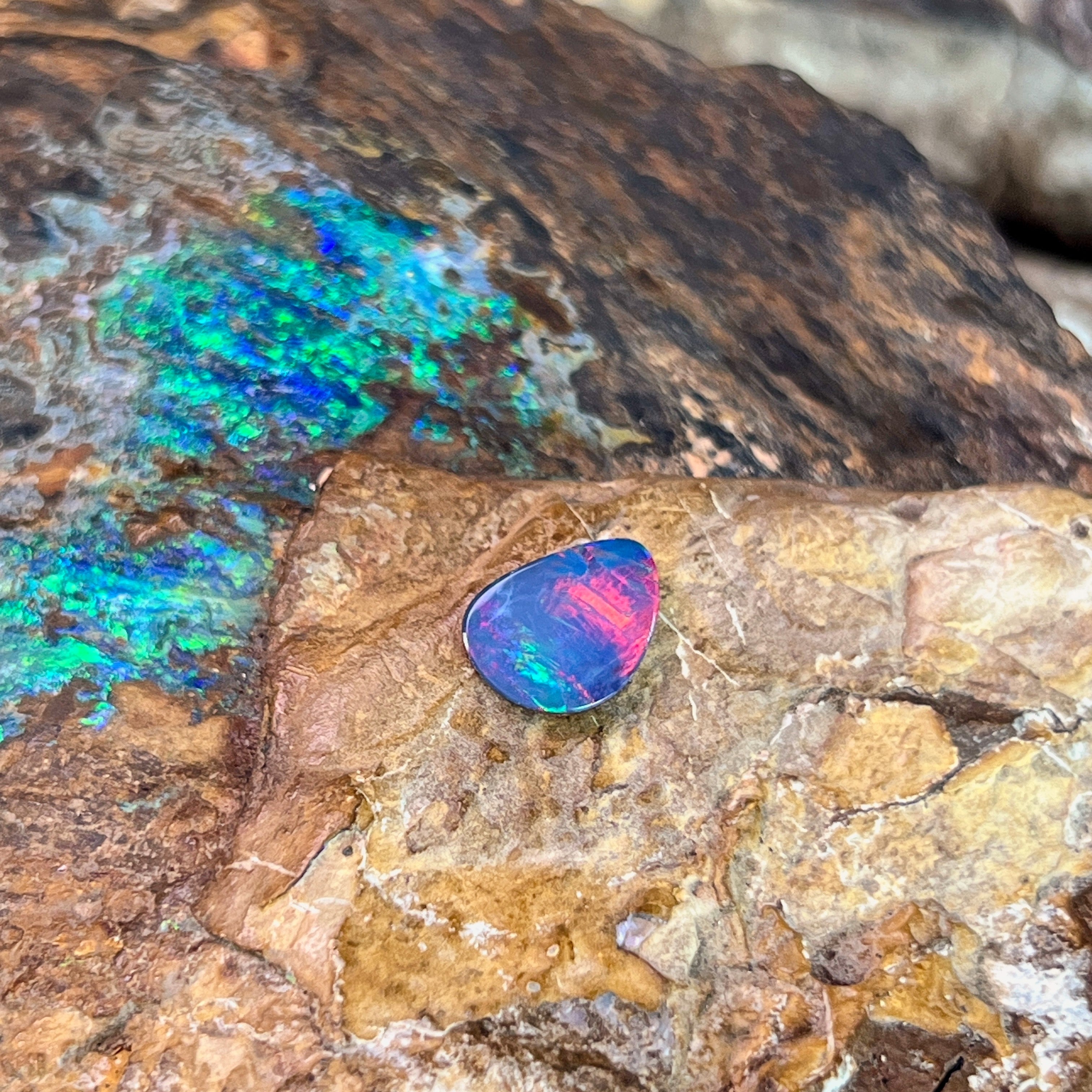 Pink-red flash over blue violet in a freeform 1.47ct Australian opal doublet on ironstone