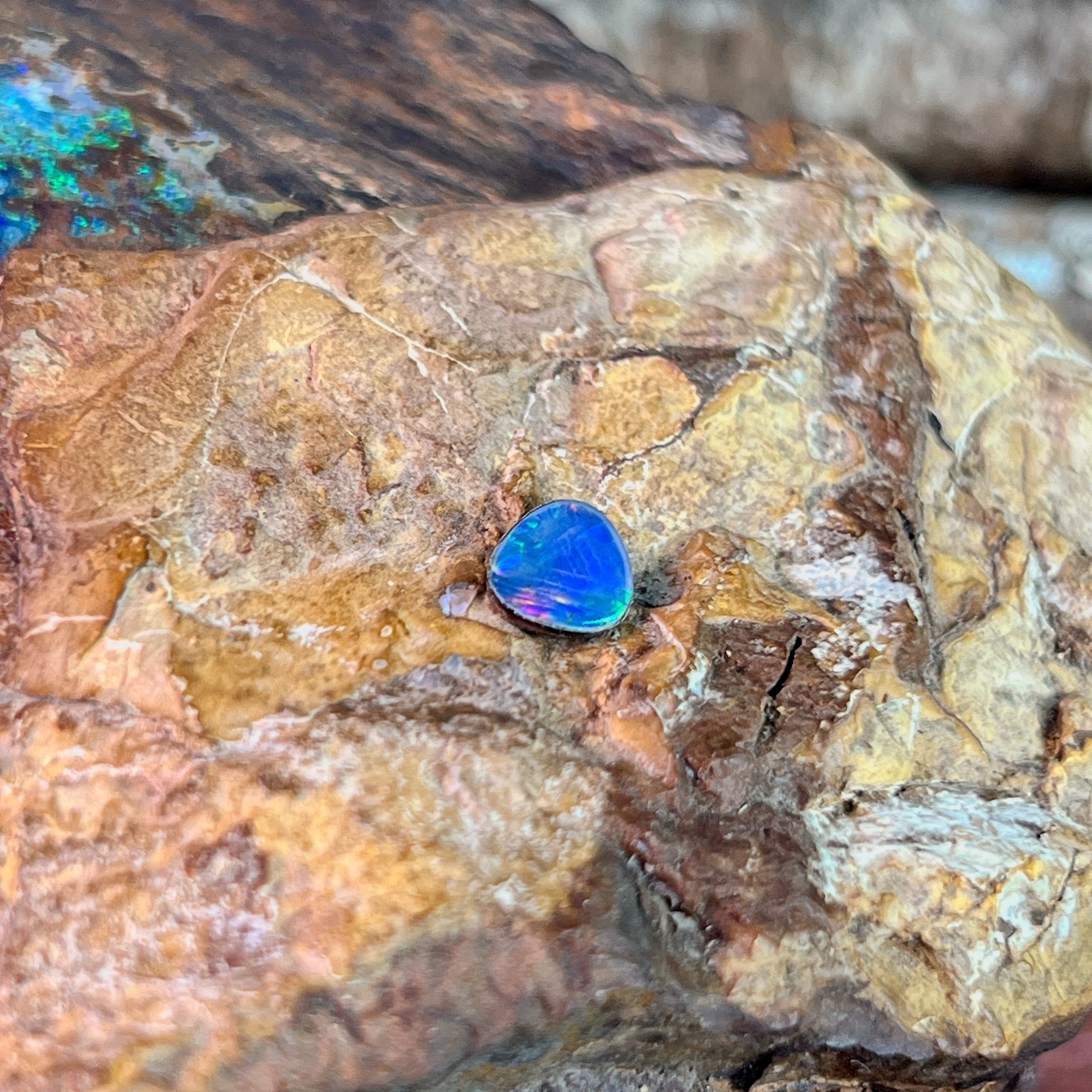 Freeform 0.70ct Australian opal doublet showing deep blue against pale ironstone