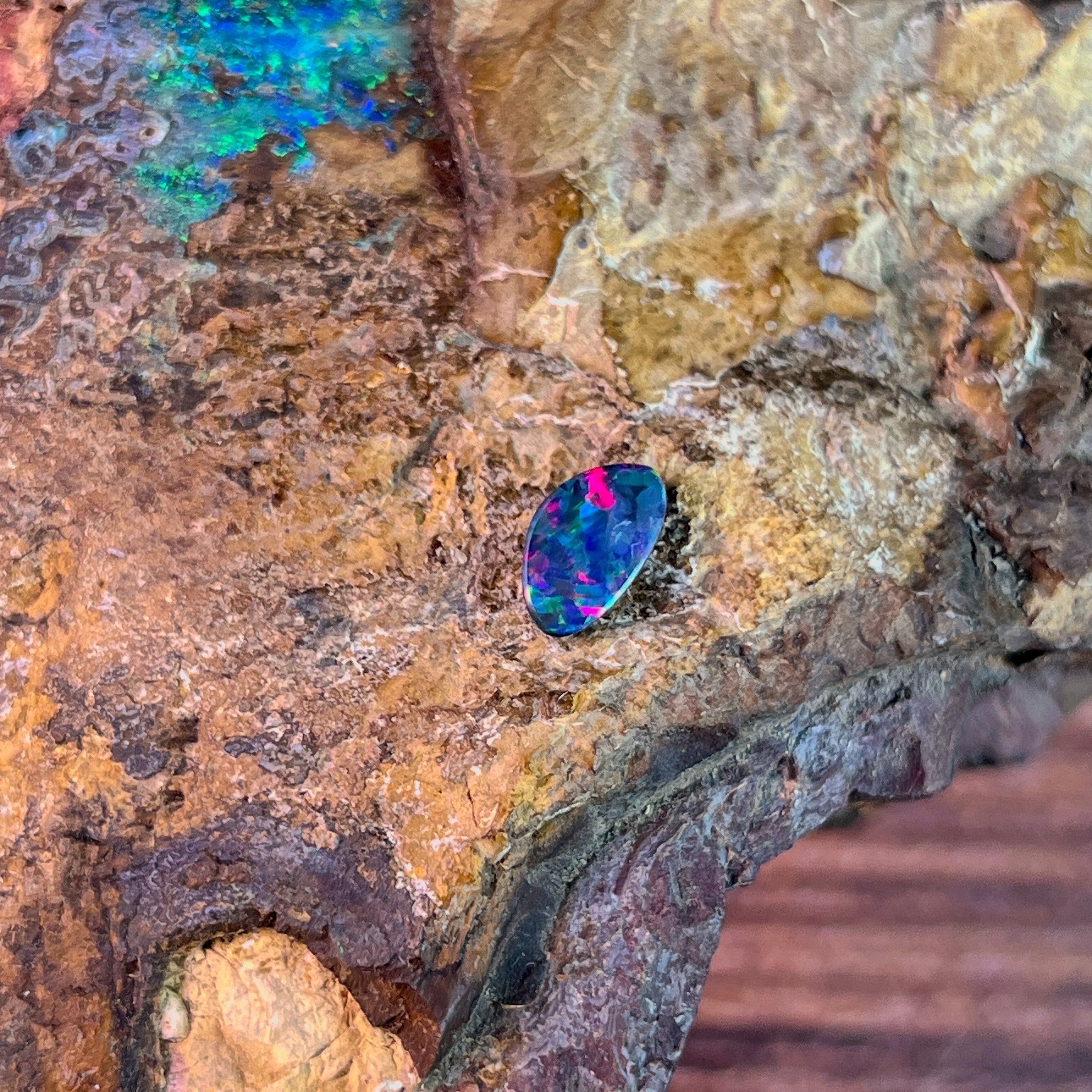 Magenta flash over blue green in a freeform 0.91ct Australian opal doublet on ironstone