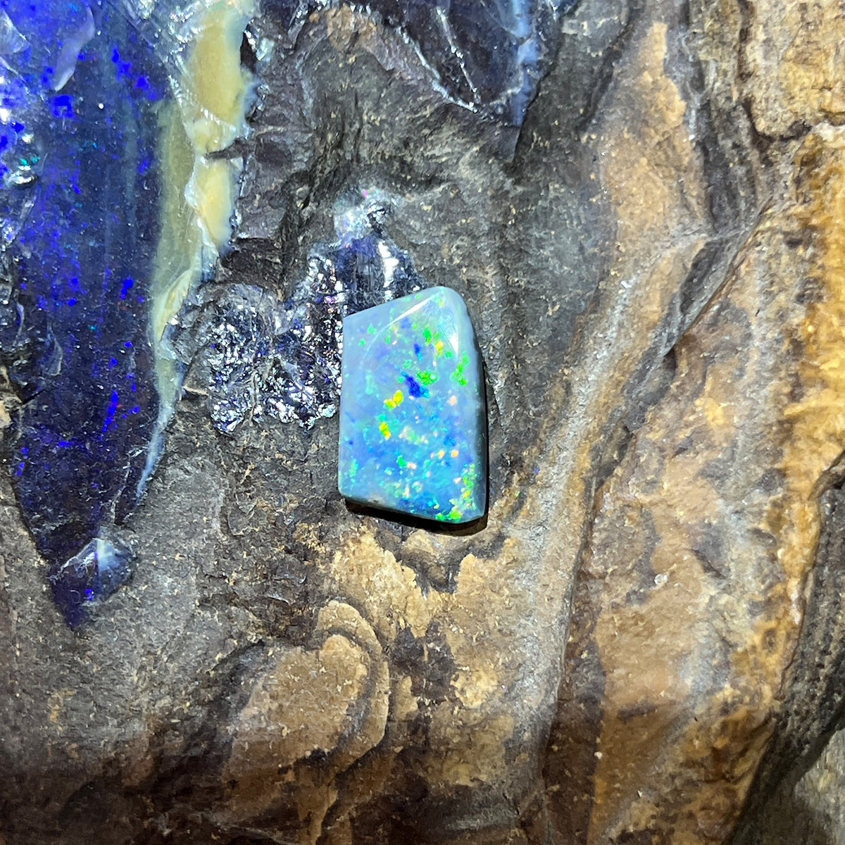 Loose solid black opal 5.15ct, rectangular, yellow, orange, green and blue pinfire, ready for a custom setting, on rock