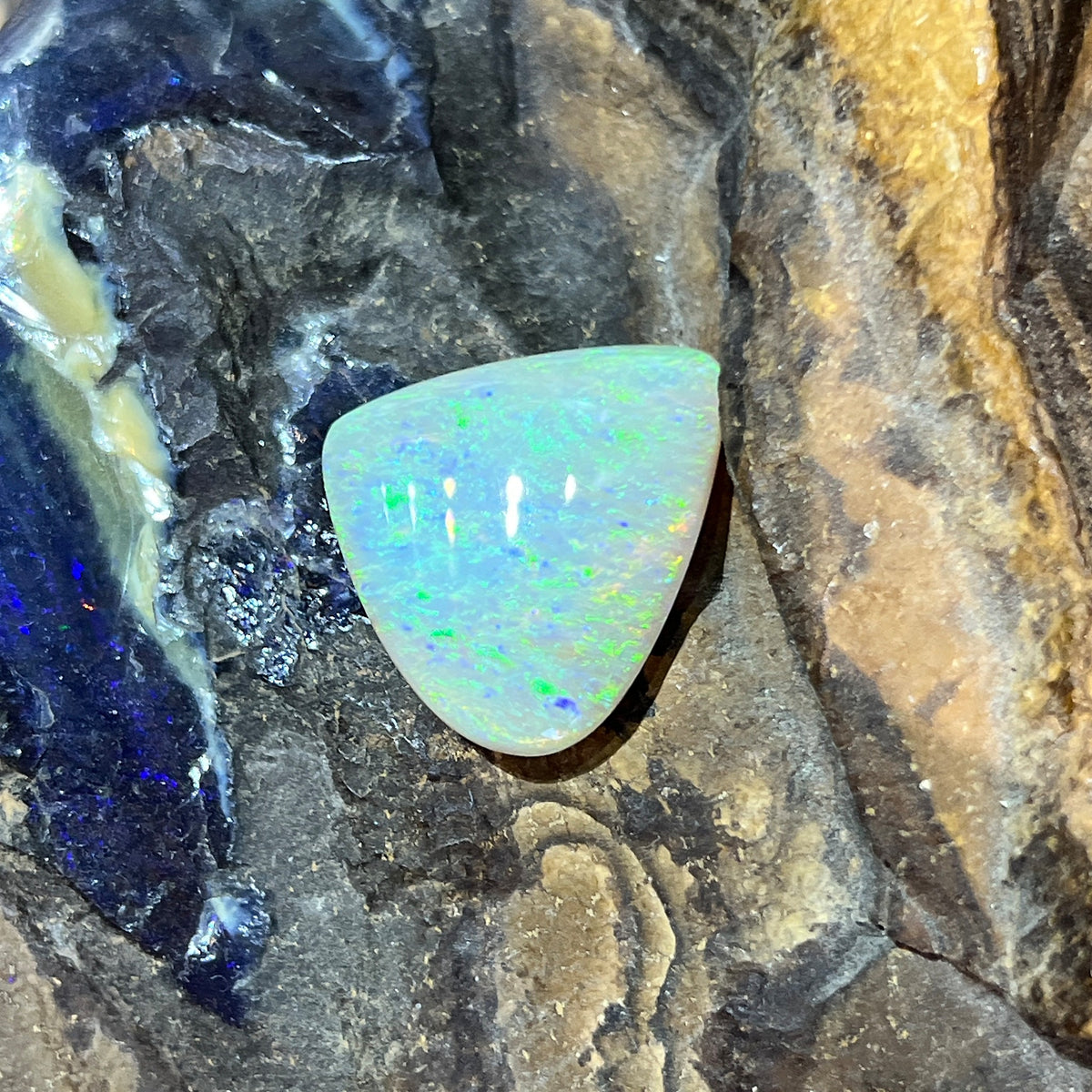 Australian crystal opal 16.50ct triangular cabochon, 23.2x20.7mm, yellow and green with a hint of blue, loose and unset, on rock