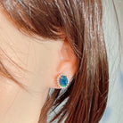 Opal triplet halo cluster earring worn on the ear, side profile view