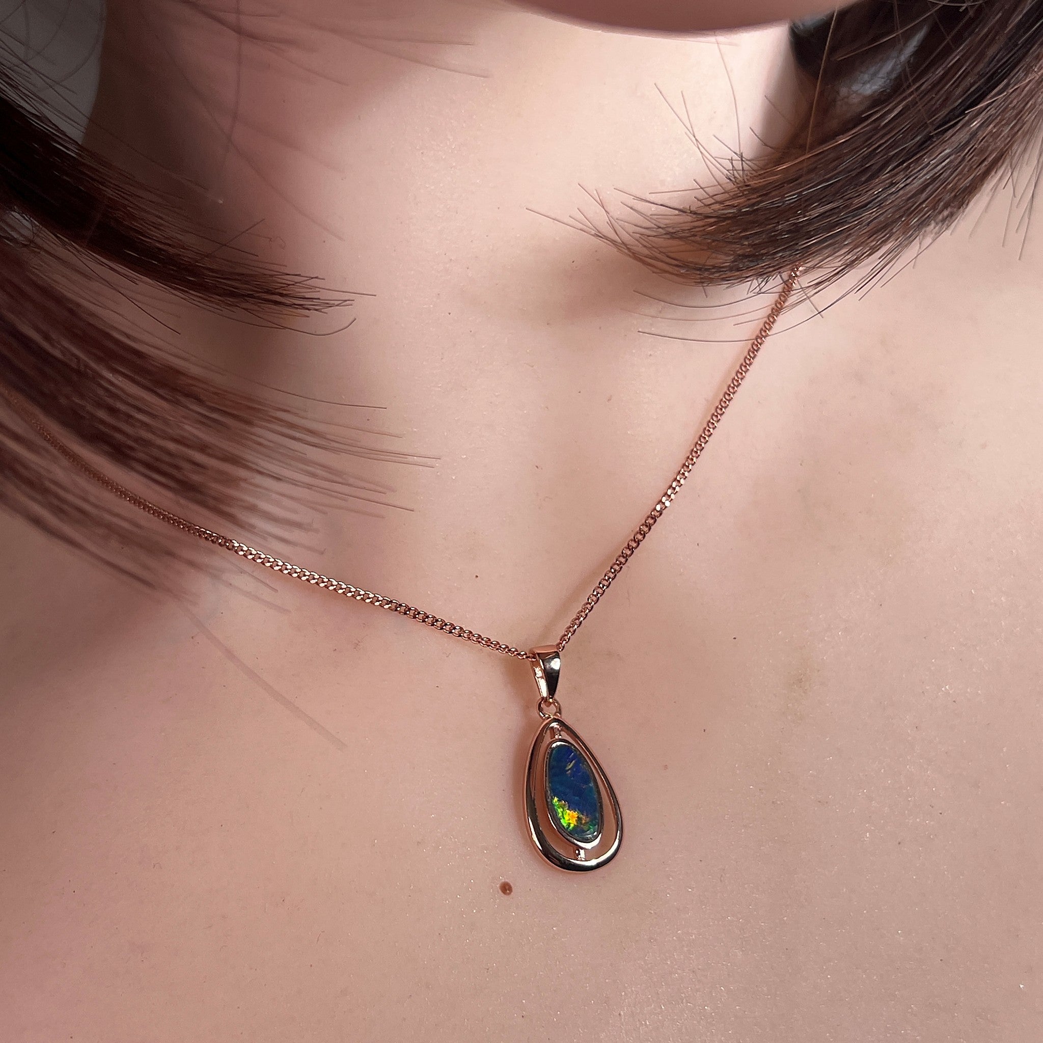 Australian opal doublet pendant worn at the neck, blue, green and red play-of-colour