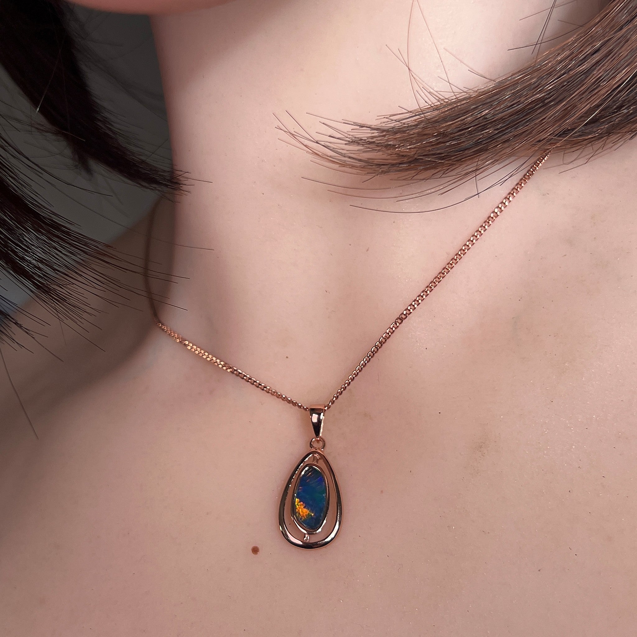 12 x 6mm freeform Australian opal doublet pendant worn at the neck, rose gold-plated silver