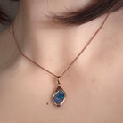 12 x 9mm freeform Australian opal doublet pendant worn at the neck, rose gold-plated silver