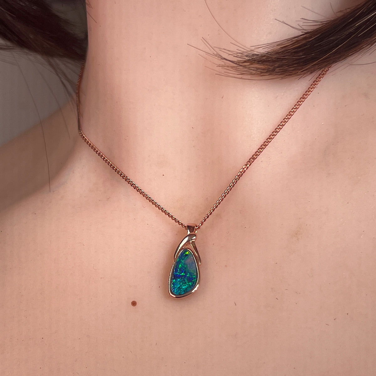 Australian opal doublet pendant worn at the neck, rose gold-plated silver, 12 x 6.5mm freeform stone