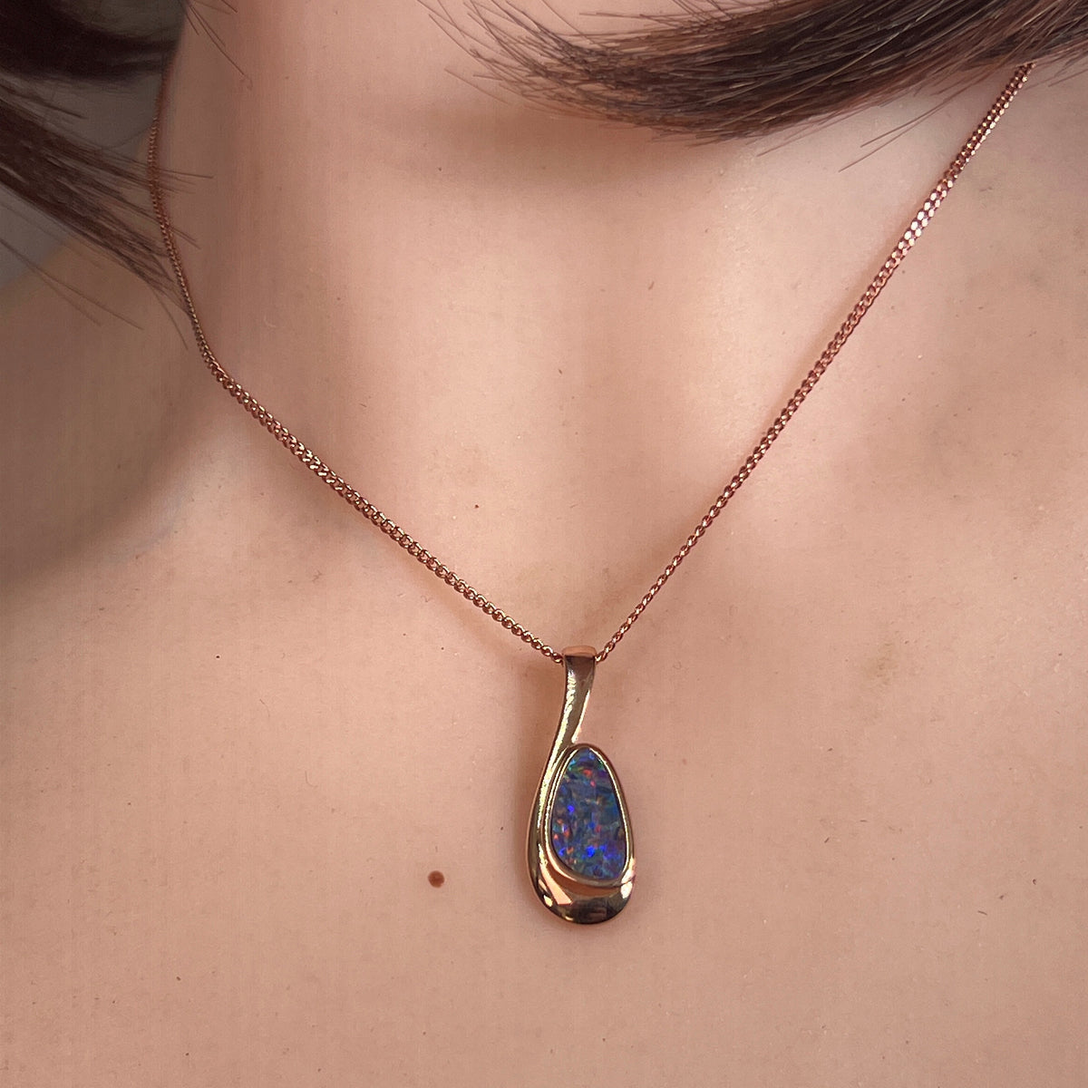 Australian opal doublet pendant worn at the neck, green, orange and violet play-of-colour