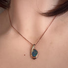 freeform Australian opal doublet pendant in rose gold-plated silver, worn at the neck