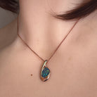 11 x 8mm freeform Australian opal doublet pendant worn at the neck, rose gold-plated silver