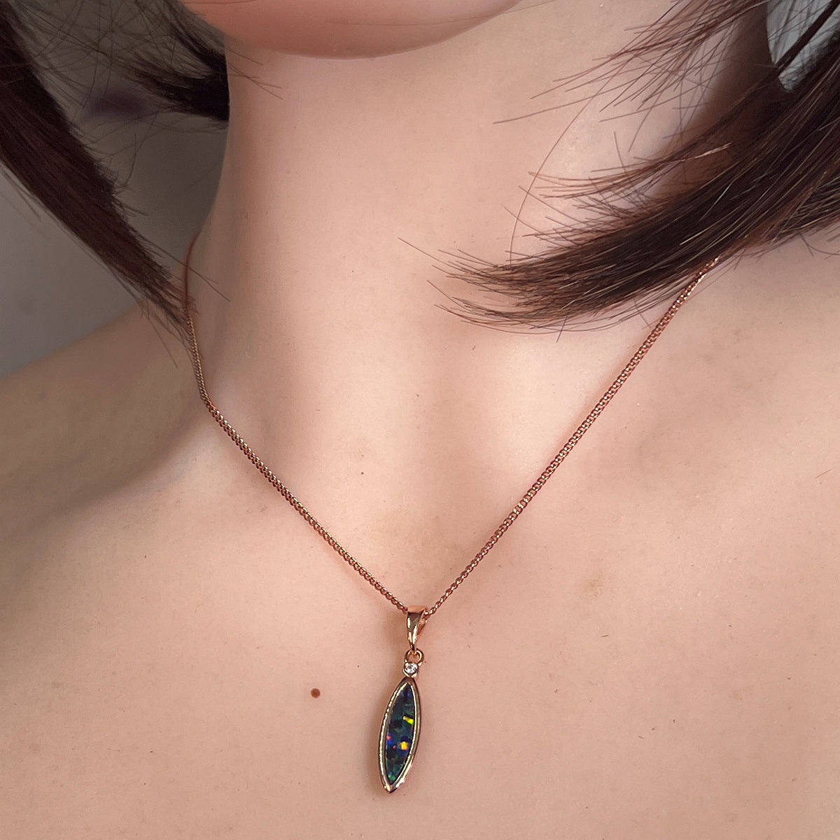Australian opal doublet pendant worn at the neck, rose gold-plated silver, 15 x 5mm marquise stone