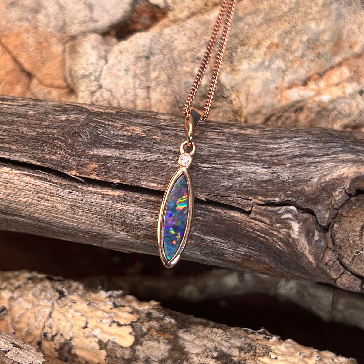 green, red, blue and yellow play-of-colour in a 16 x 5mm marquise Australian opal doublet pendant