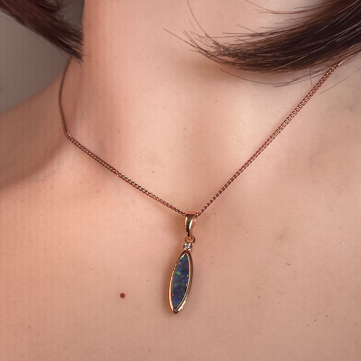16 x 5mm marquise Australian opal doublet pendant worn at the neck, rose gold-plated silver