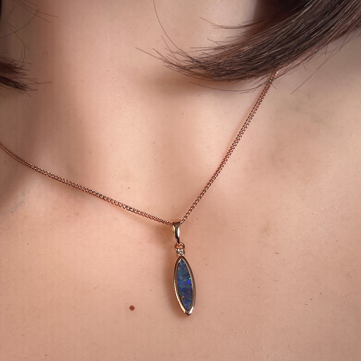 Worn Australian opal doublet pendant in rose gold-plated silver, green, red, blue and yellow, 16 x 5mm