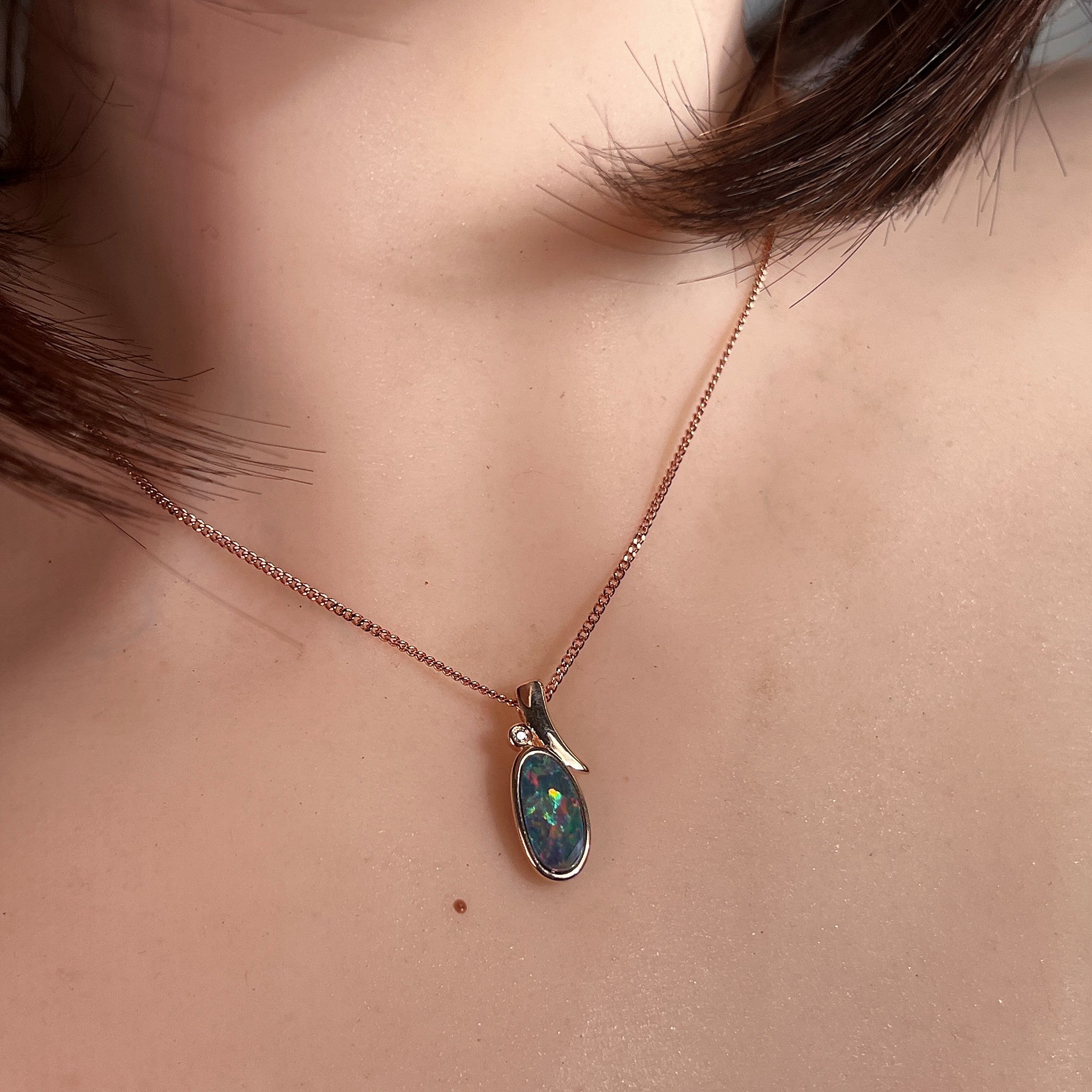 Worn Australian opal doublet pendant in rose gold-plated silver, yellow, red, blue and green, 13 x 7mm