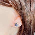 Australian opal doublet earrings worn on the ear, red, blue and green play-of-colour