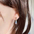 13 x 5mm pear-shaped Australian opal doublet earrings worn on the ear, rose gold-plated silver