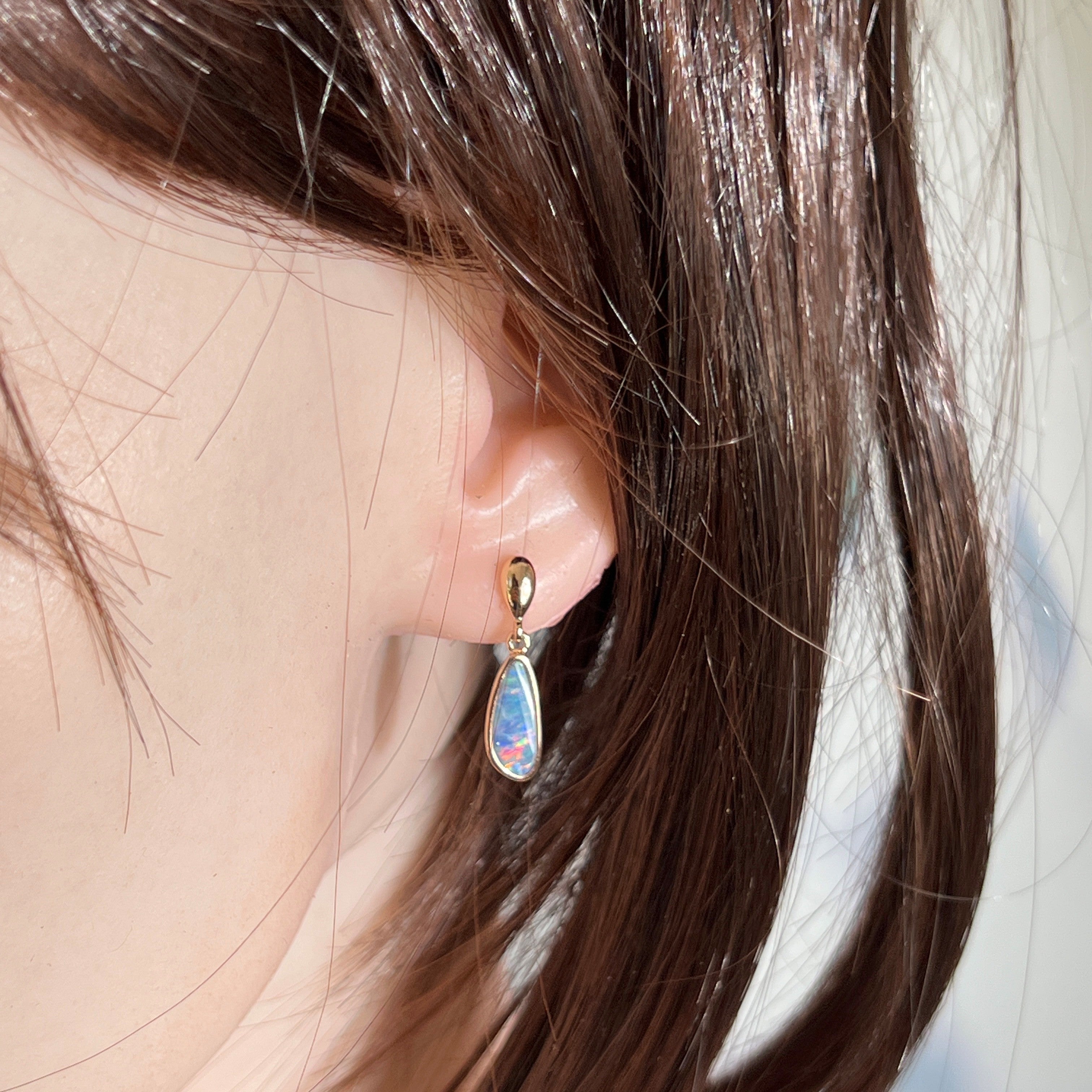 13 x 5mm pear-shaped Australian opal doublet earrings worn on the ear, rose gold-plated silver