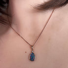 Australian opal doublet pendant worn at the neck, blue, red, yellow and green play-of-colour