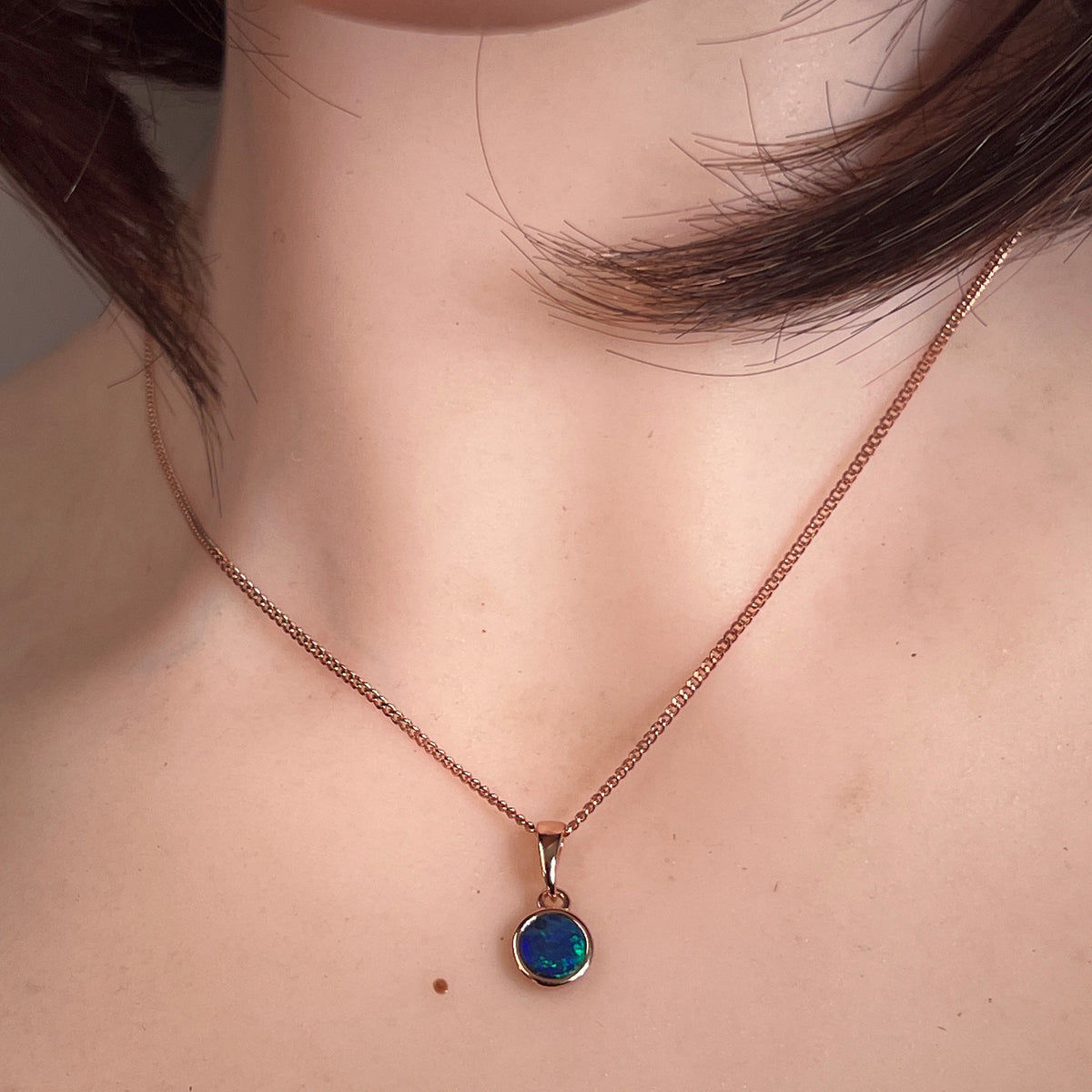 Worn Australian opal doublet pendant in rose gold-plated silver, green, red and blue, 6mm