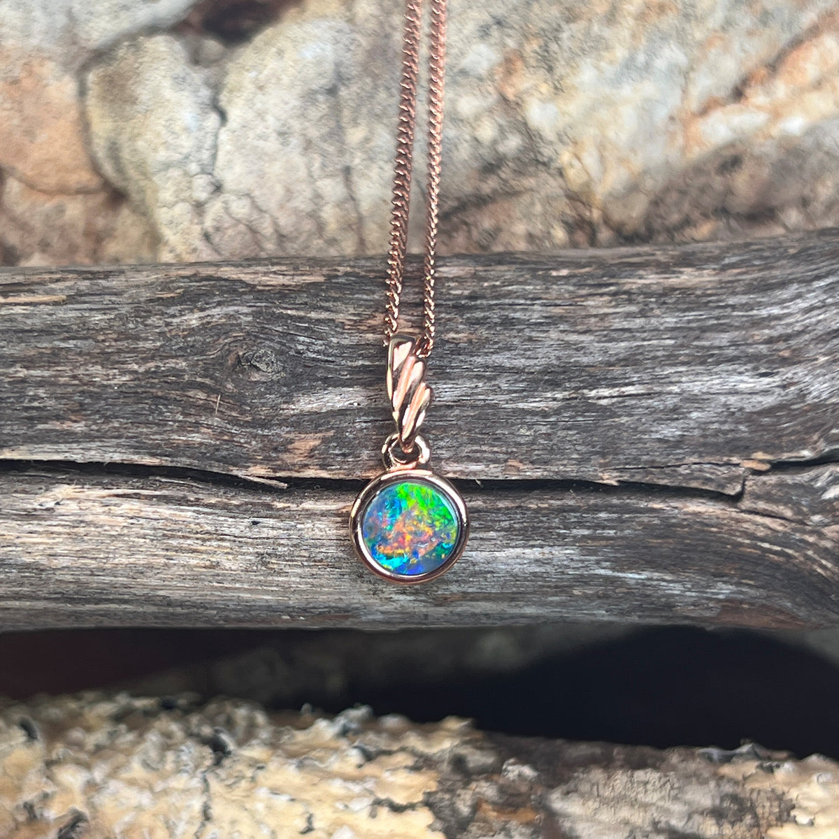 green, red, blue and yellow play-of-colour in a 6mm round Australian opal doublet pendant