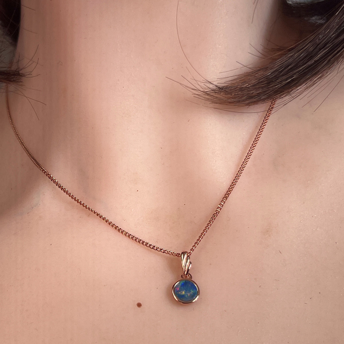 Worn Australian opal doublet pendant in rose gold-plated silver, green, red, blue and yellow, 6mm