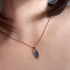 11 x 5.5mm triangular Australian opal doublet pendant worn at the neck, rose gold-plated silver