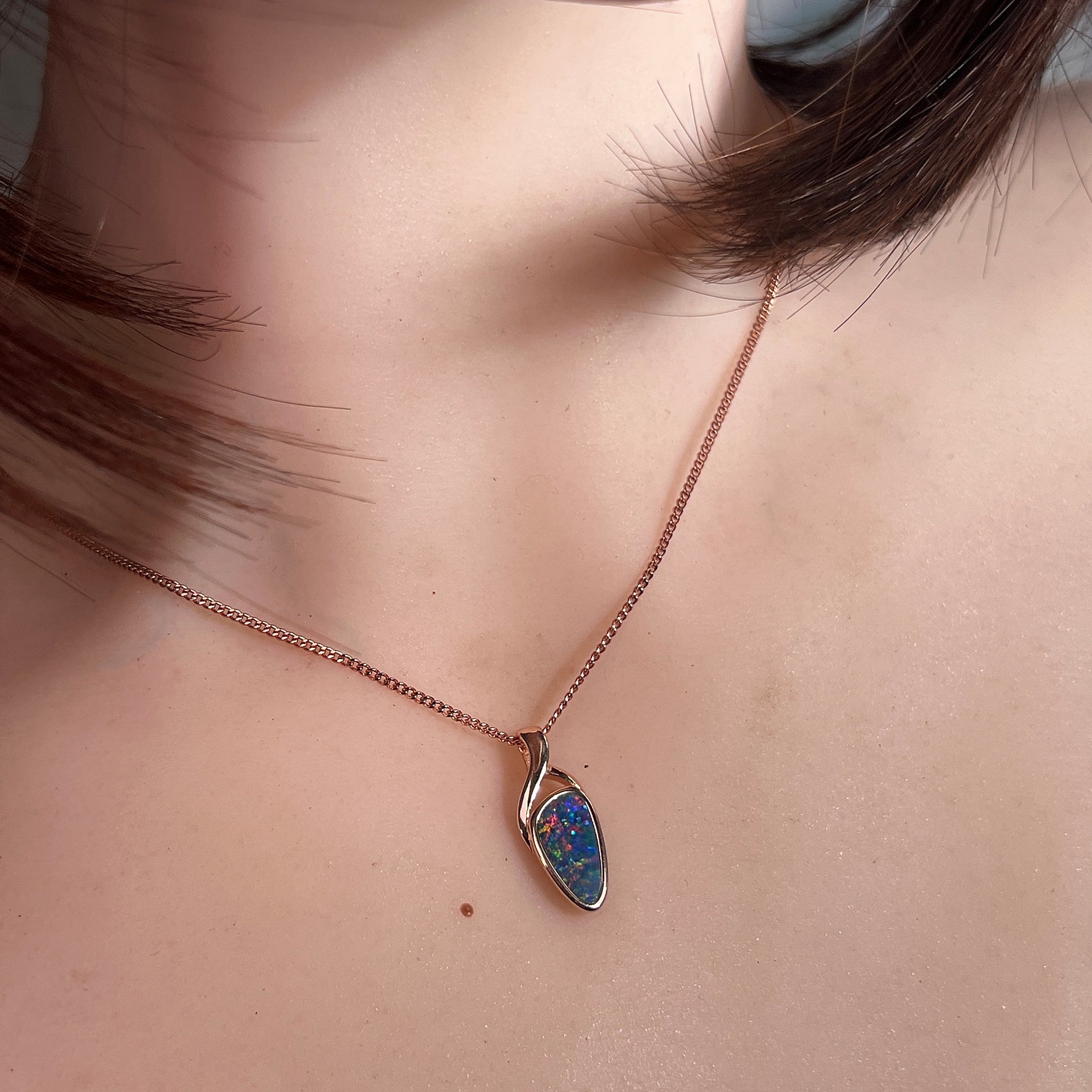 11 x 5.5mm triangular Australian opal doublet pendant worn at the neck, rose gold-plated silver