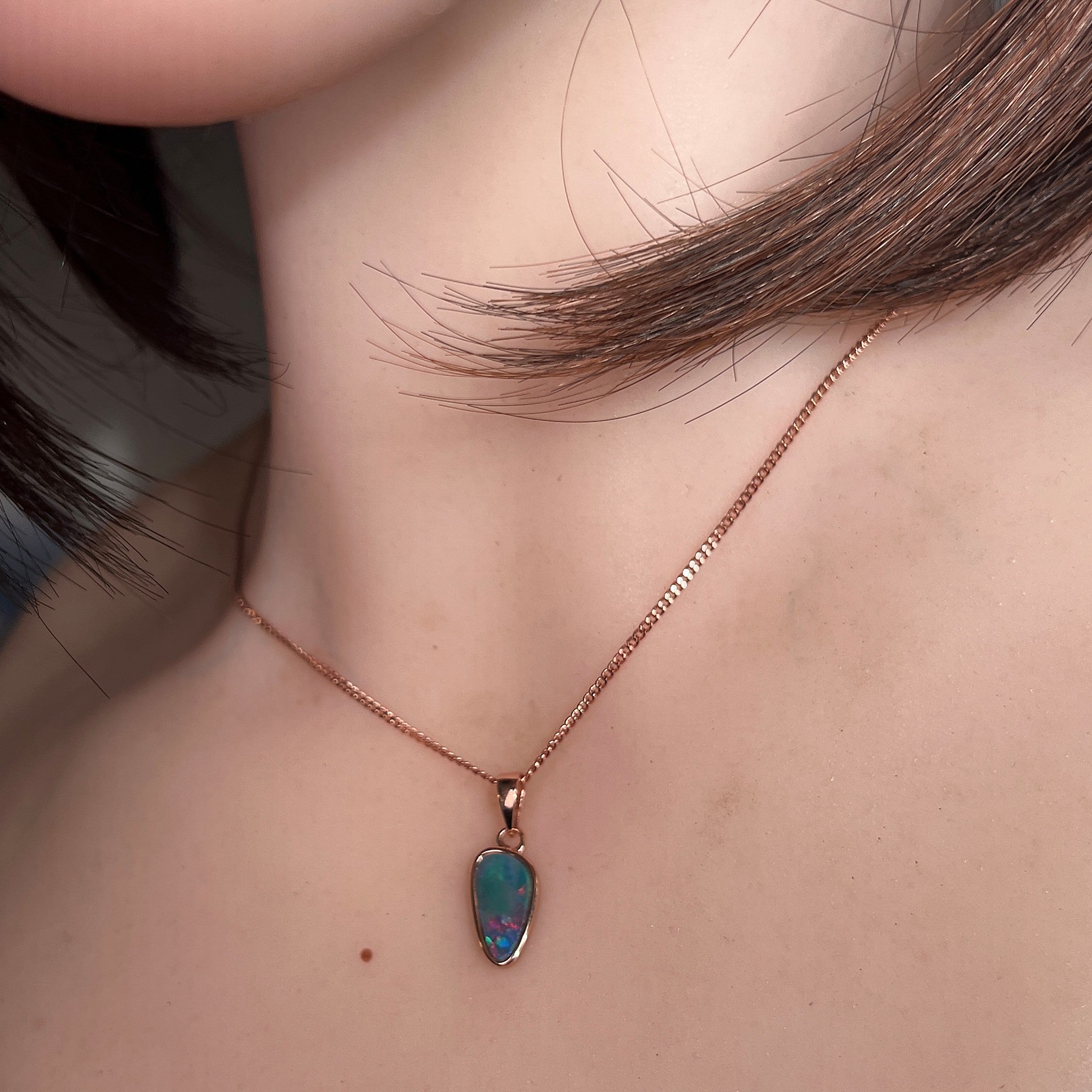 12 x 6.5mm triangular Australian opal doublet pendant worn at the neck, rose gold-plated silver