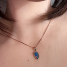 Worn Australian opal doublet pendant in rose gold-plated silver, red, green and blue, 12 x 6.5mm