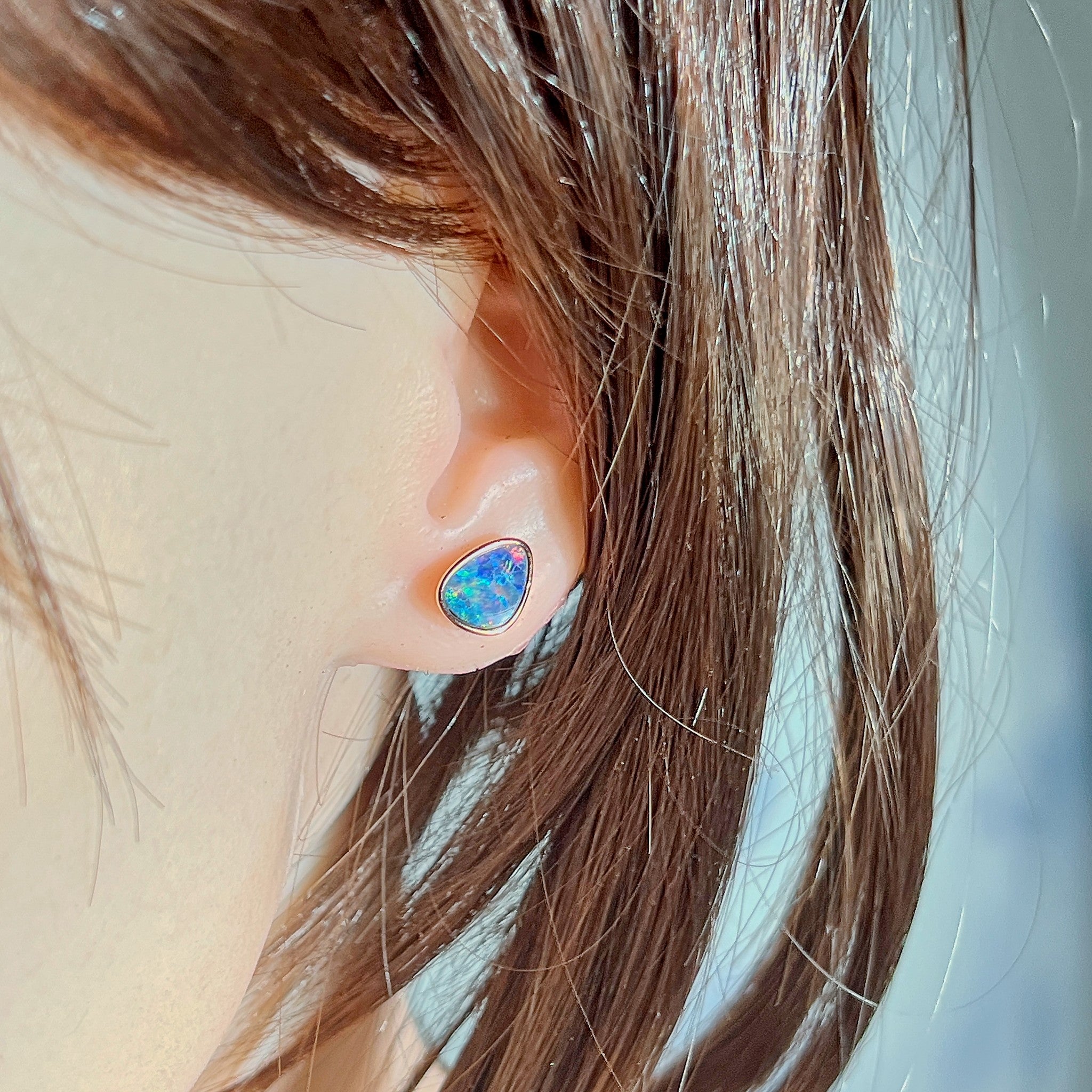 10 x 8mm triangular Australian opal doublet earrings worn on the ear, rose gold-plated silver