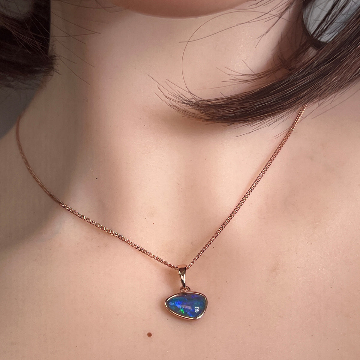 Worn Australian opal triplet pendant in yellow gold-plated silver, red, green and blue, 12 x 8mm