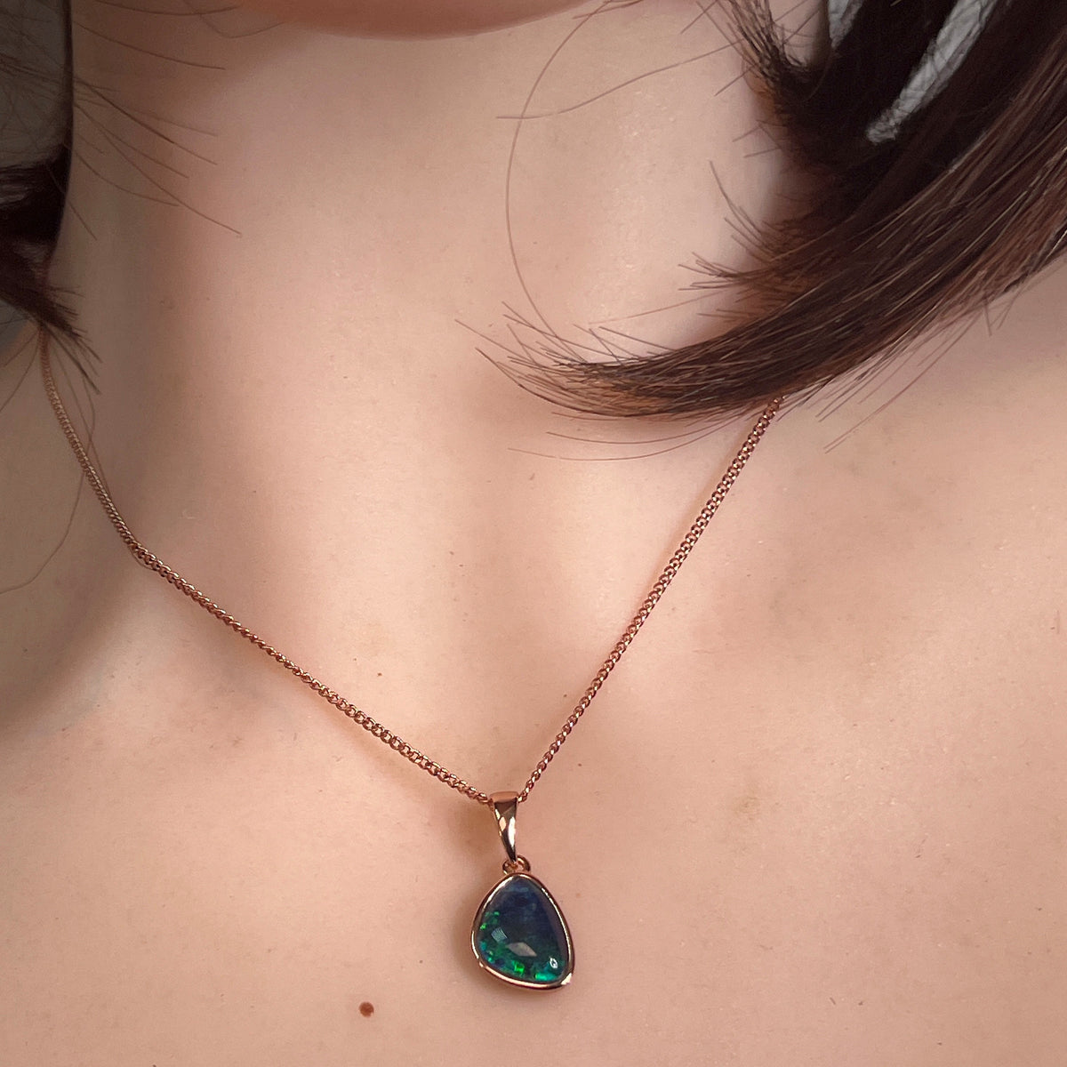 Worn Australian opal triplet pendant in rose gold-plated silver, red, green and blue, 12 x 8mm