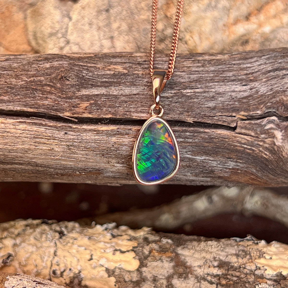 Australian opal triplet pendant, rose gold-plated silver, 12 x 8mm stone showing red, green and blue