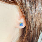 7mm round Australian opal triplet earrings worn on the ear, rose gold-plated silver