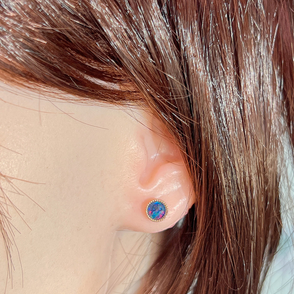 6mm round Australian opal triplet earrings worn on the ear, rose gold-plated silver