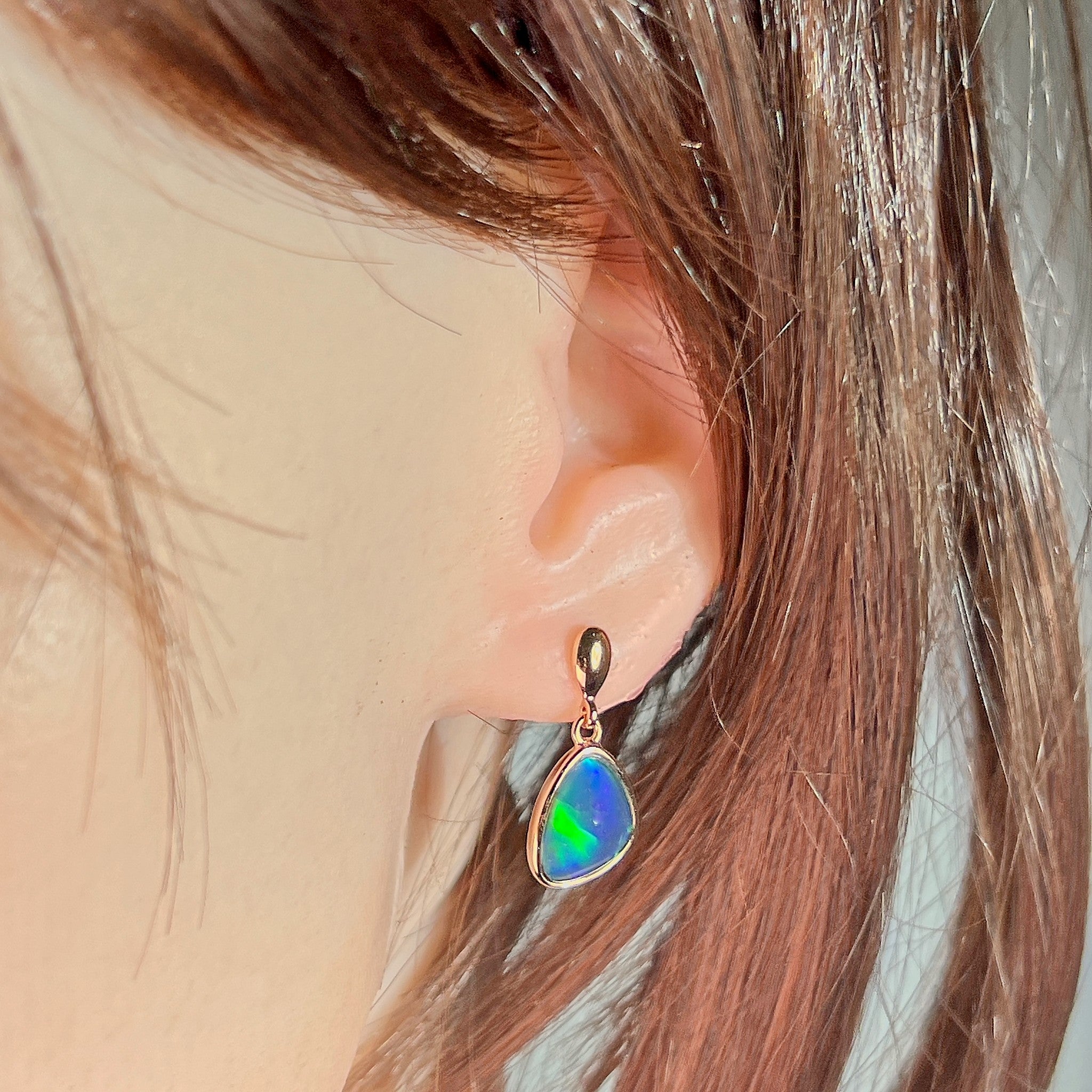 12.5 x 10.5mm triangular Australian opal triplet earrings worn on the ear, rose gold-plated silver
