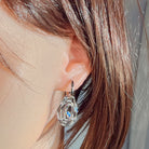 Sterling silver circle opal earring worn in the ear