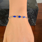 Sterling silver bracelet with three opal doublets worn on the wrist, full view of the linked stones